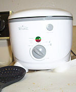 A white plastic device shaped like a bucket, with controls on the front.
