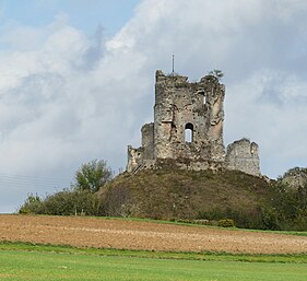 Donjon du Châteauneuf-sur-Epte vu depuis le village de Château-sur-Epte. Champs au premier plan, donjon sur la motte à l'arrière.