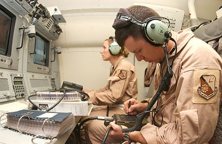 Crew members uploading software onto an E-8 during preparations for a flight