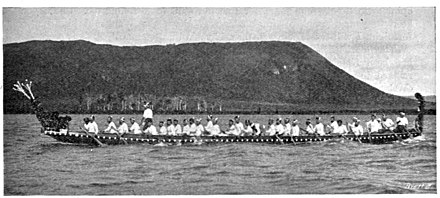 Māori war canoe on lake, about 2 dozen on board