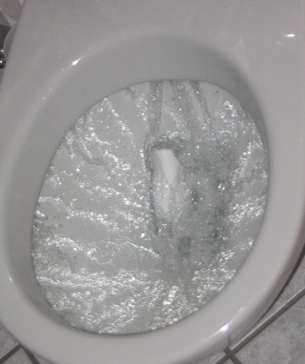 A flush toilet bowl during flushing action