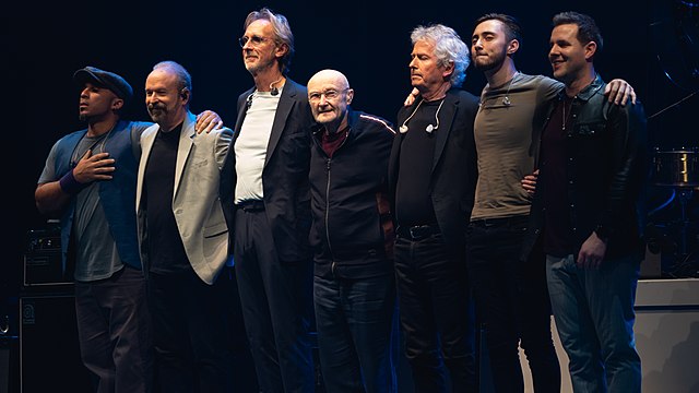 Genesis performing in 2022 (L–R): Daniel Pearce, Daryl Stuermer, Mike Rutherford, Phil Collins, Tony Banks, Nic Collins and Patrick Smyth