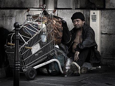 Homeless man with transfunctionalized and transformed shopping cart in Paris