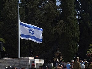 ’n Israeliese vlag waai op halfmas op die Gedenkdag vir Israel se Gevalle Soldate en die Slagoffers van Terrorisme by die militêre begraafplaas op Rehovot