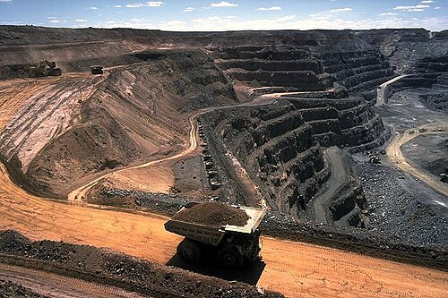 Surface gold mine with haul truck in foreground