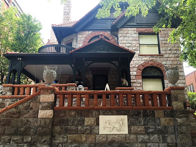 Exterior photo of 1889 era stone house with dark trim owned by Margaret Brown