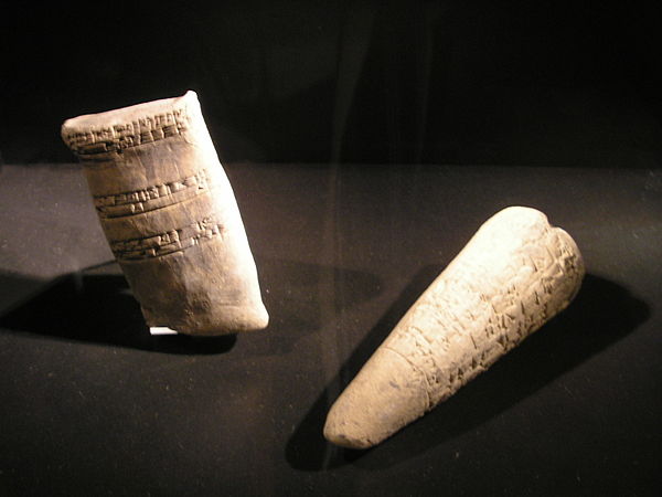 Left: Cuneiform clay tablet. Old Babylonian, 1900-1700 BC Right: Sumerian cuneiform "foundation stone". This clay cone was embedded in a wall, and con