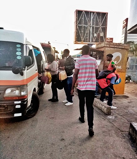 Pedestrian getting on minibus at the local bus stop in Lusaka