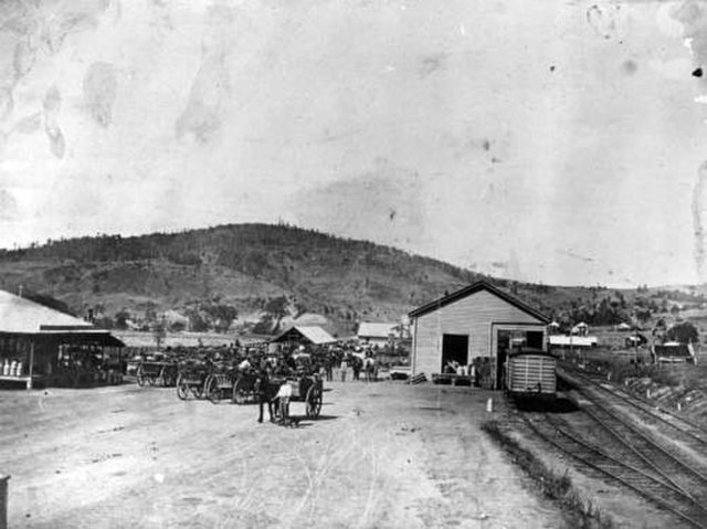 Horse-drawn wagons at the Lowood Railway Station with the Queensland Farmer's Co-Op. Ltd on the opposite side of the street.