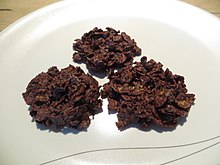 Tres rosas de arena de chocolate negro en un plato blanco.