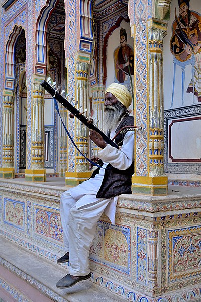 Local Shekhavati old man playing an old instrument in Dr. Ramnath Podar Haveli Museum by Sharvarism