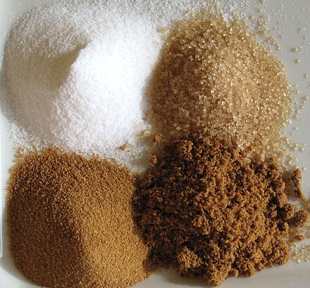 Sugars; clockwise from top left: Refined, unrefined, brown, unprocessed cane