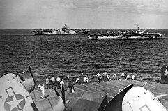 Zdjęcie przedstawia 3 lotniskowce znajdujące się na Pacyfiku. Po lewej widoczny jest lotniskowiec "USS Hornet", a po prawej "USS Independence". Zdjęcie zostało wykonane 26 stycznia 1945 roku z pokładu lotniskowca "USS Wasp".