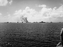 The target fleet after test Able. The aircraft carrier Saratoga is right-center with Independence burning at left-center. The ex-Japanese battleship Nagato is between them. The ship at left, next to the battleship Pennsylvania, is trying to wash down the radioactivity with water from the lagoon. View of the target fleet after Crossroads test Able on 1 July 1946.jpg