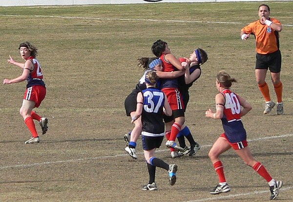 A Darebin Falcons player is wrapped up in a gang tackle by two Melbourne University opponents in the 2006 WVFL senior women's Grand Final. The field u