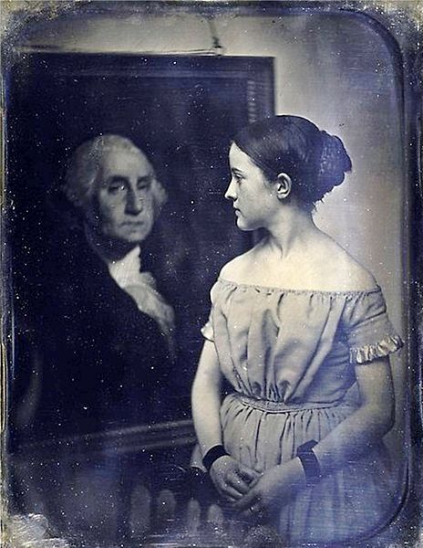 Photographie d'une jeune fille avec le portrait de George Washington, vers 1850. Ce portrait envoûtant semble également être une allégorie d'allégeance, dans laquelle la jeune fille dirige l'attention du spectateur vers le tableau symbolique de George Washington. Les études récentes suggèrent que ce daguerreotype est en fait une copie d'un autre daguerreotype, ajoutant encore au jeu complexe des regards fixes, mais jusqu'ici le sens et l'objet exact de cette image énigmatique ne sont pas connus. Metropolitan Museum of Art.