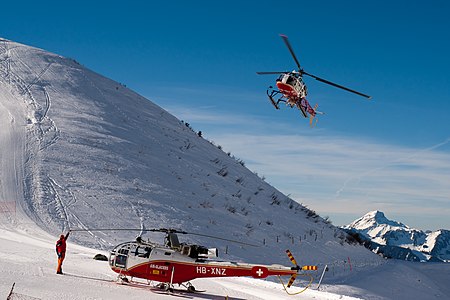 Un Lama en approche pour se poser à côté d'une Alouette III à Leysin.