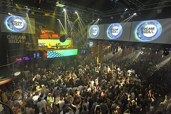 Photographie de la foule à Amnesia face à la cabine du DJ.  L'image est capturée depuis une position élevée et regarde les clubbers.