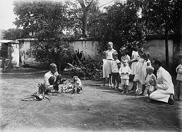 Trained monkey performing for an audience of children (1900–20)