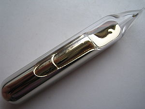 Some silvery-gold metal， with a liquid-like texture and lustre， sealed in a glass ampoule