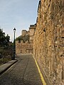 Looking along the Vennel, with the 17th-century Telfer Wall on the right, towards the 16th-century Flodden Wall bastion. Edinburgh Castle behind