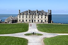 A reenactment in action during lunch hour at Fort Niagara. The skyline of Toronto may be seen on the horizon. Front view of the French Castle at Fort Niagara.jpg