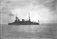 Fotografie válečné lodi kotvící při pohledu z levoboku.