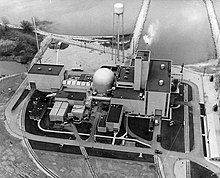 Overhead view of the plant shortly after it began operations in 1963. The cooling loops and turbogenerators are in the building on the right of the confinement dome, fuel processing on the left.