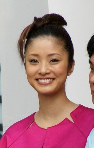 Photographie couleur, portrait de tête d'une femme souriante.