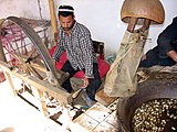 Spinning av silketråd på hånddreven rokk ved en silkefabrikk i oasebyen Khotan i Kina.