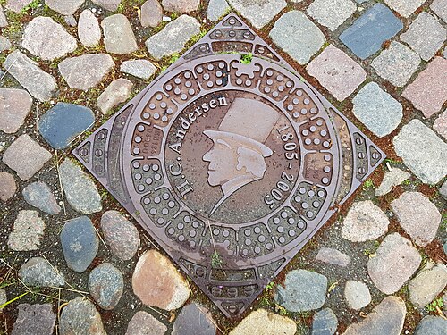 Manhole cover with the portrait of Hans Christian Andersen in the street "Hans Jensens Stræde" in Odense