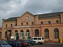 Bahnhof Königs Wusterhausen mit Empfangsgebäude, den südlich davon stehenden Funktionsbauten, den historischen Bahnsteigüberdachungen, der Wartehalle auf Bahnsteig 2 sowie dem Beamtenwohnhaus, dem Übernachtungsgebäude und dem Wasserturm an der Storkower Straße