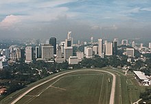 Kuala lumpur cityscape in the 1980s before KLCC was created. The race track in the foreground was replaced by the Petronas Tower and KLCC Park. Kuala Lumpur skyline in the 1980s.jpg