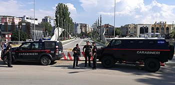 KFOR-MSU Carabinieri patrols, in front of the Ibar Bridge, in Mitrovica, Kosovo. (2019). MSU Mitrovica Manbox - Ibar Bridge summer 2019.jpg