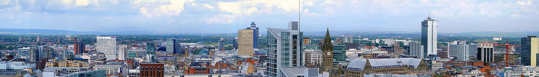 The skyline of central Manchester with the clock tower of the Town Hall visible.