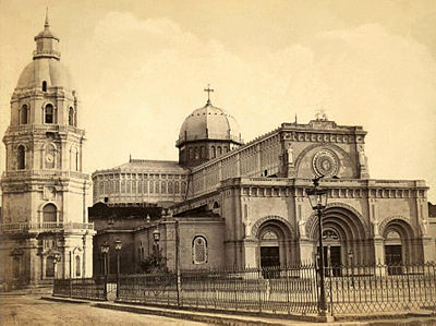 The newly reconstructed Manila Cathedral, destroyed by the 1863 earthquake, with the surviving belfry from the previous cathedral.