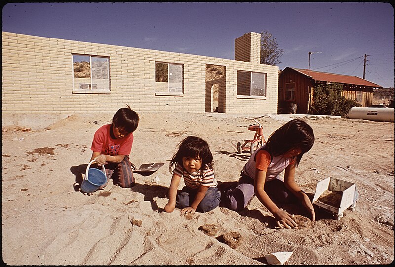 File:NAVAJO CHILDREN MAKE MUD "FLAT-BREAD". NEW HOUSING IN BACKGROUND - NARA - 544424.jpg