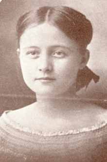 A young white woman with straight hair parted center