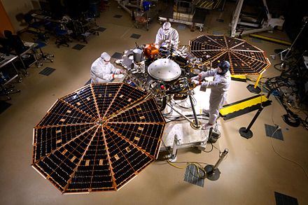 The InSight lander with solar panels deployed in a cleanroom.