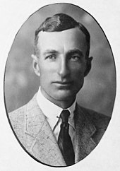 An ovular photographic portrait of a man in a jacket and tie