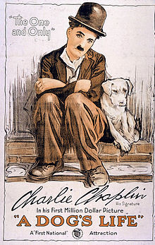 Affiche montrant Charlot l'air triste assis sur un muret en briques à côté d'un petit chien blanc.