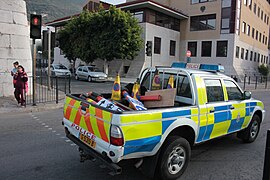 Pickup truck delivering road pilons and signage in a city.