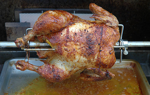 Rotisserie chicken cooking on a horizontal rotisserie