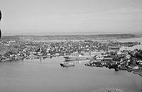 Flyfoto fra ca. 1947 som viser Tønsberg by med Byfjorden foran, Kaldnes mekaniske verksted nord på Nøtterøy til høyre og i bakgrunnen fjordbassenget Træla øst for kanalen med Presterødkilen som en bugt mot venstre. Foto: Widerøe/Vestfoldmuseene