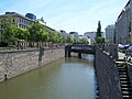 A small river with a bridge crossing it in Vienna.