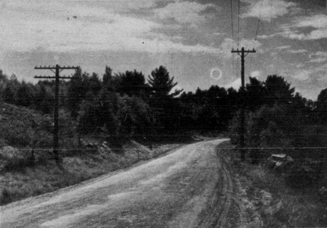 A total solar eclipse over a country road