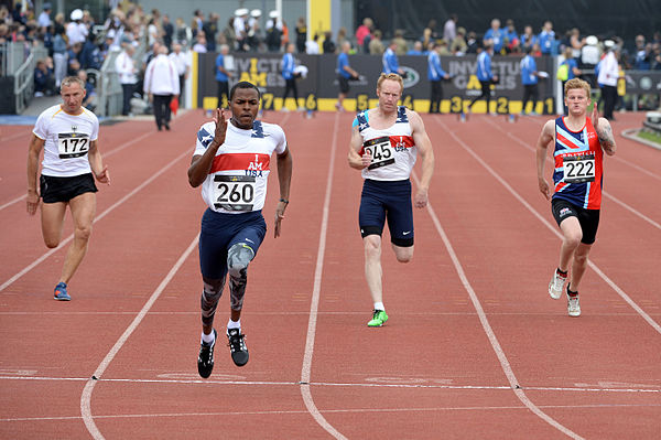 Four runners from Germany, the United Kingdom and the United States during a 100-metre qualifying heat at the 2014 Invictus Games