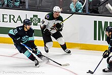 Hayton in action against the Seattle Kraken in 2023. Arizona Coyotes at Seattle Kraken - 2023-04-06 - Matty Beniers and Barrett Hayton (52800892695).jpg