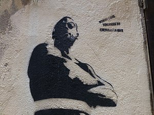Pochoir monochrome dans le port de Bastia reprenant un vers de Baudelaire « Homme libre toujours tu chériras la mer ».