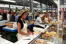 A cheese merchant in a French market Cormeilles Market 9 Artlibre jnl.jpg